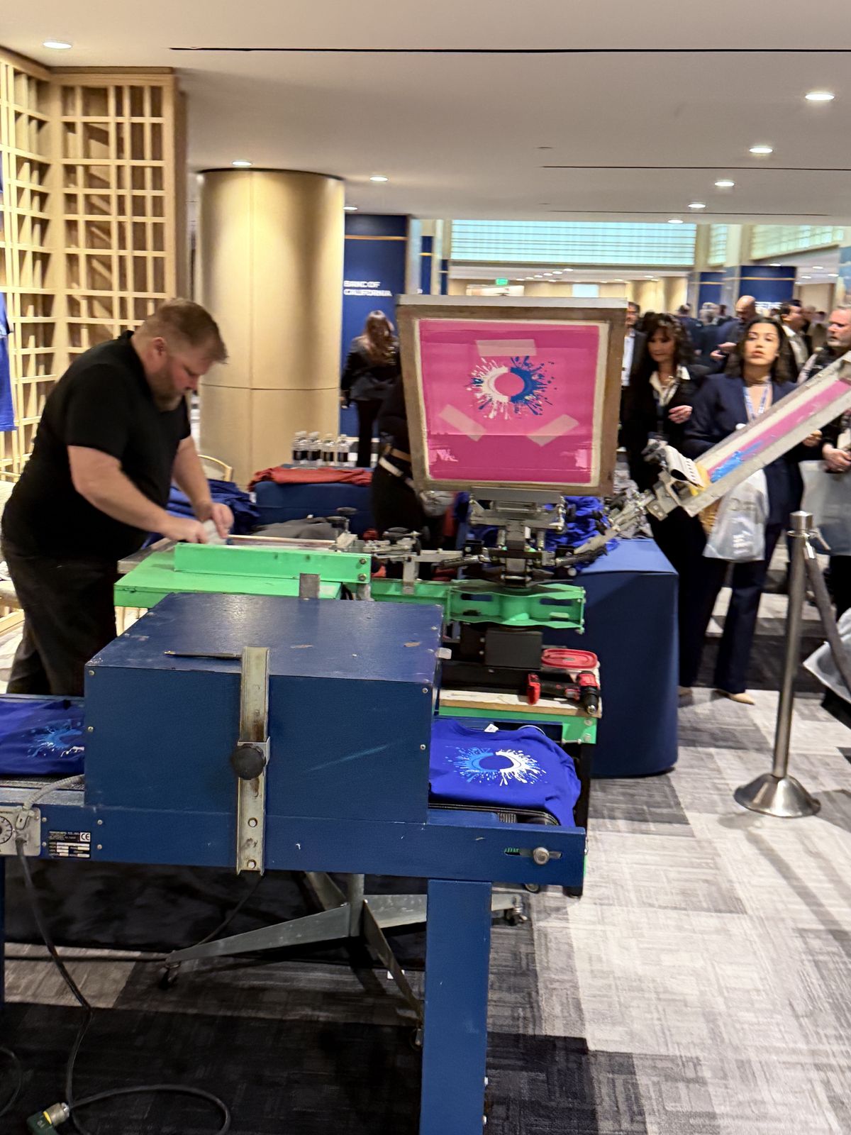 Guests watching custom merch get printed live at a Minneapolis event